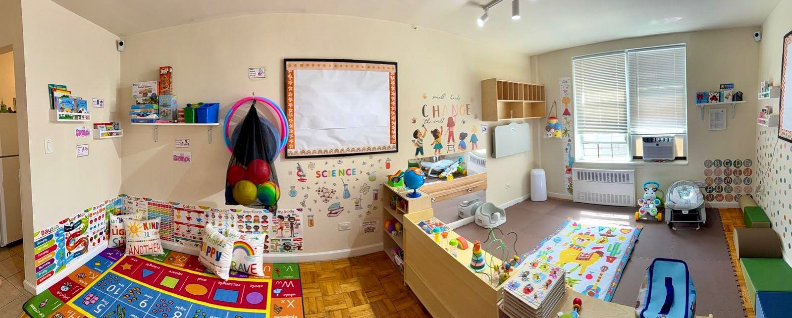 Playroom with colorful mats, toys, and a whiteboard