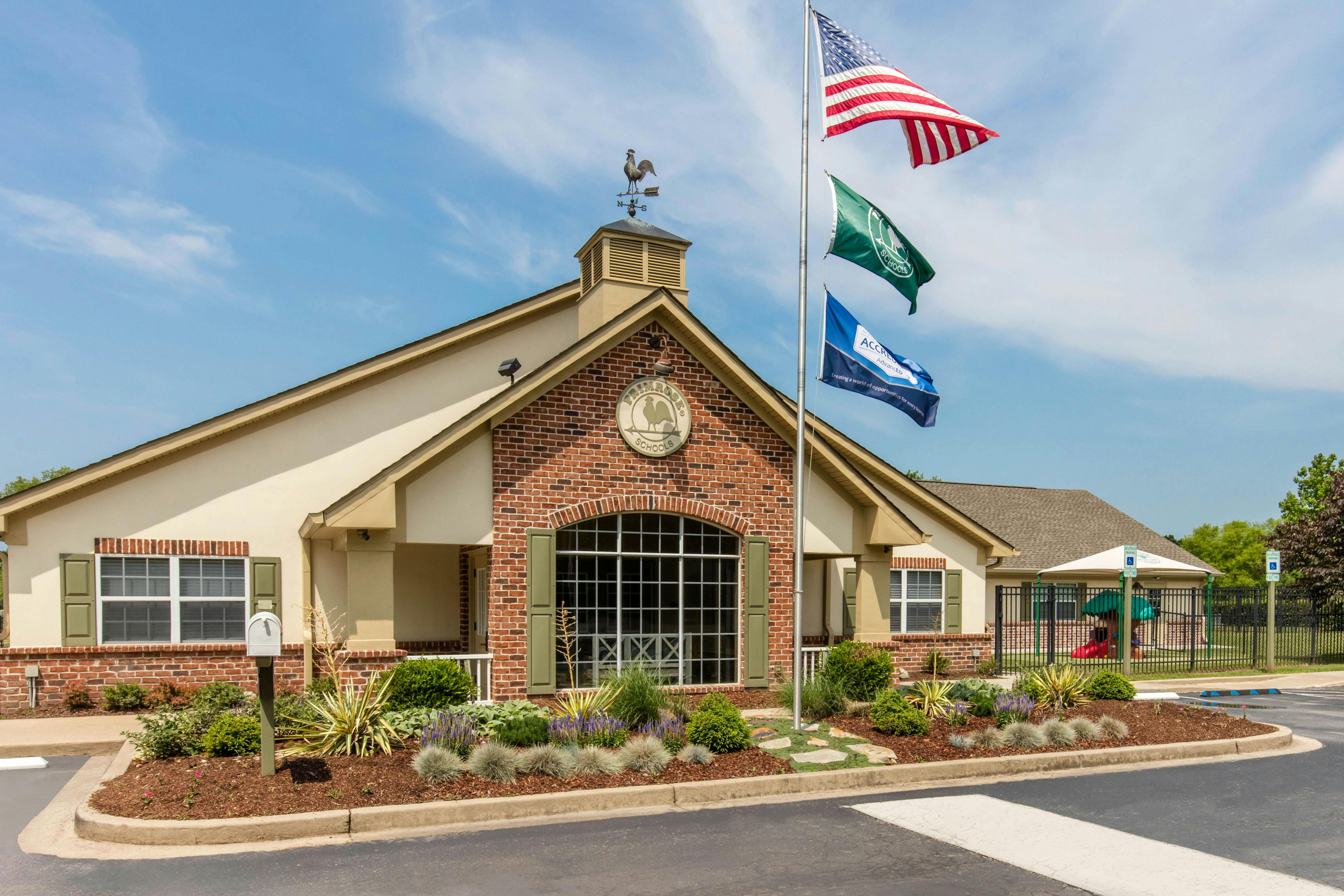 Primrose School building exterior with flags and landscaping