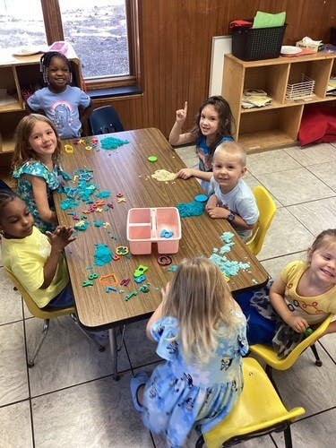 Children playing with modeling clay at a table