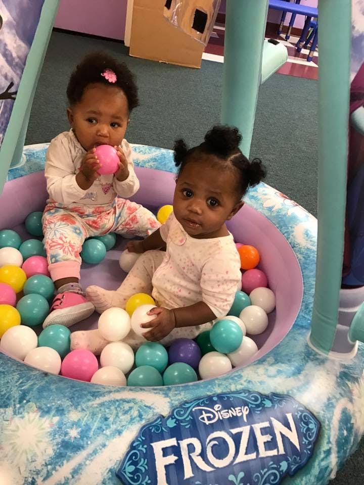 Two children playing in a ball pit with a Disney Frozen logo