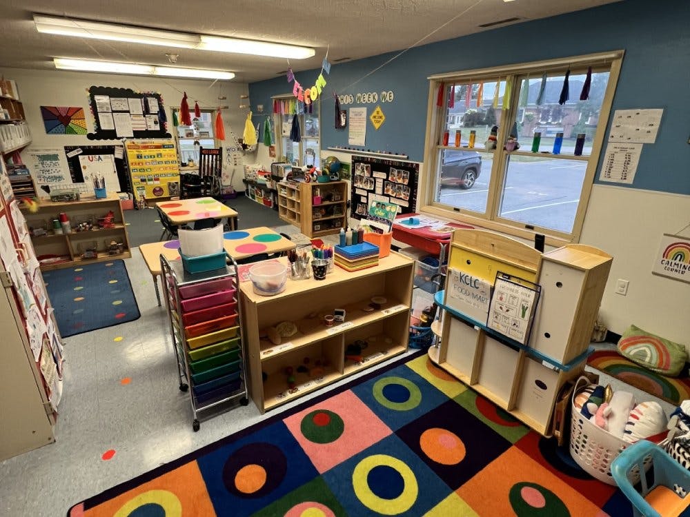 Colorful and organized classroom with tables, shelves, and learning materials