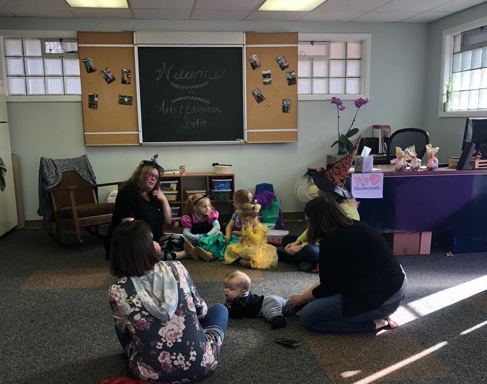 Adults and children sitting on the floor in a room