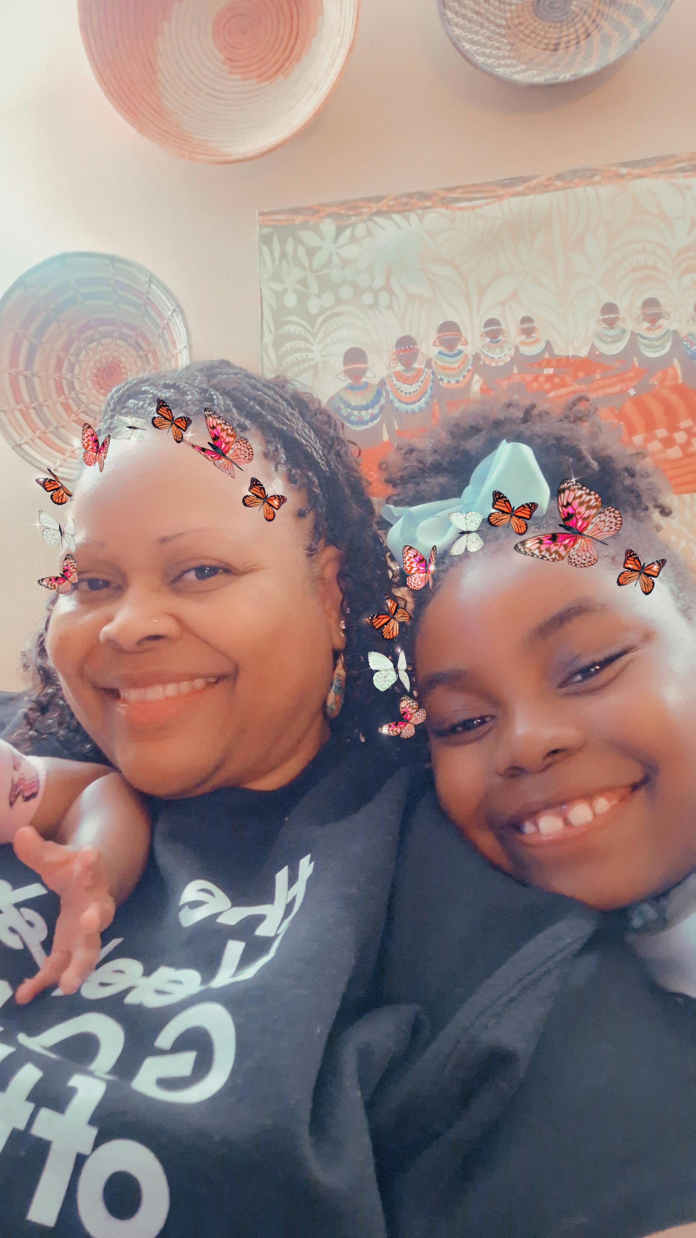 A person and a child smiling closely together with butterfly photo filters