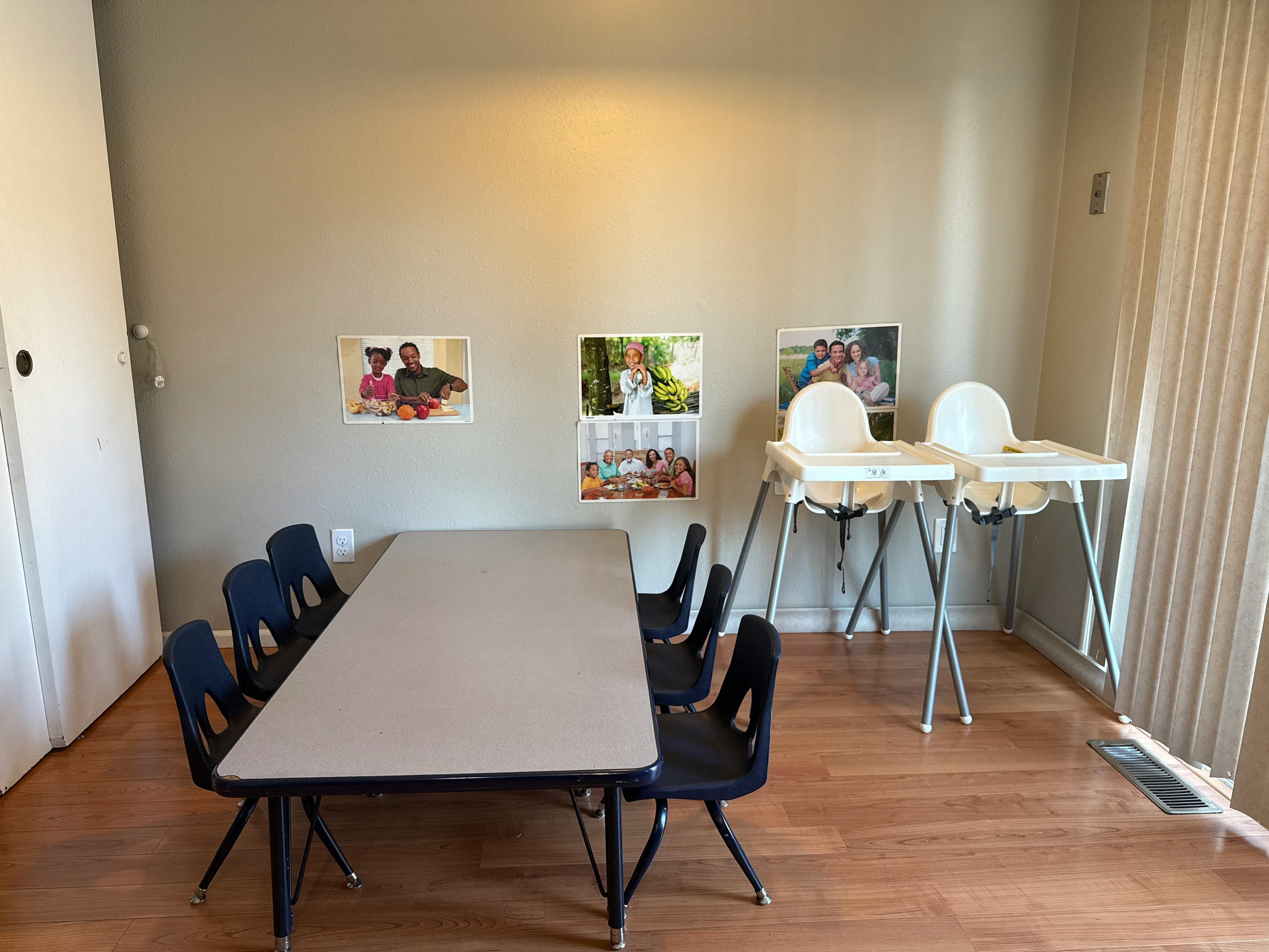 Long table with chairs and two high chairs in a room