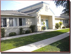Building with a blue door and a green lawn