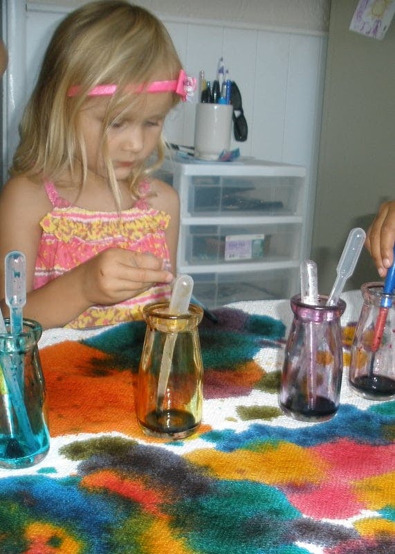 Child using droppers with colorful liquids