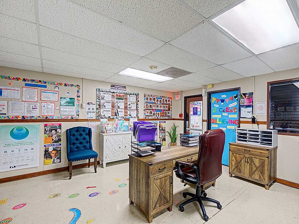 An office or classroom with a desk, chair, and bulletin boards