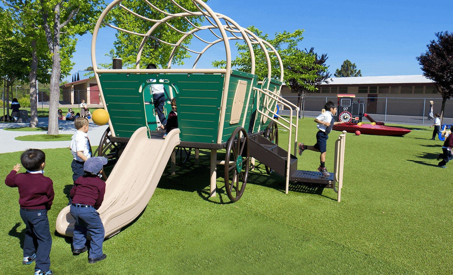 Children playing on a wagon-shaped playground