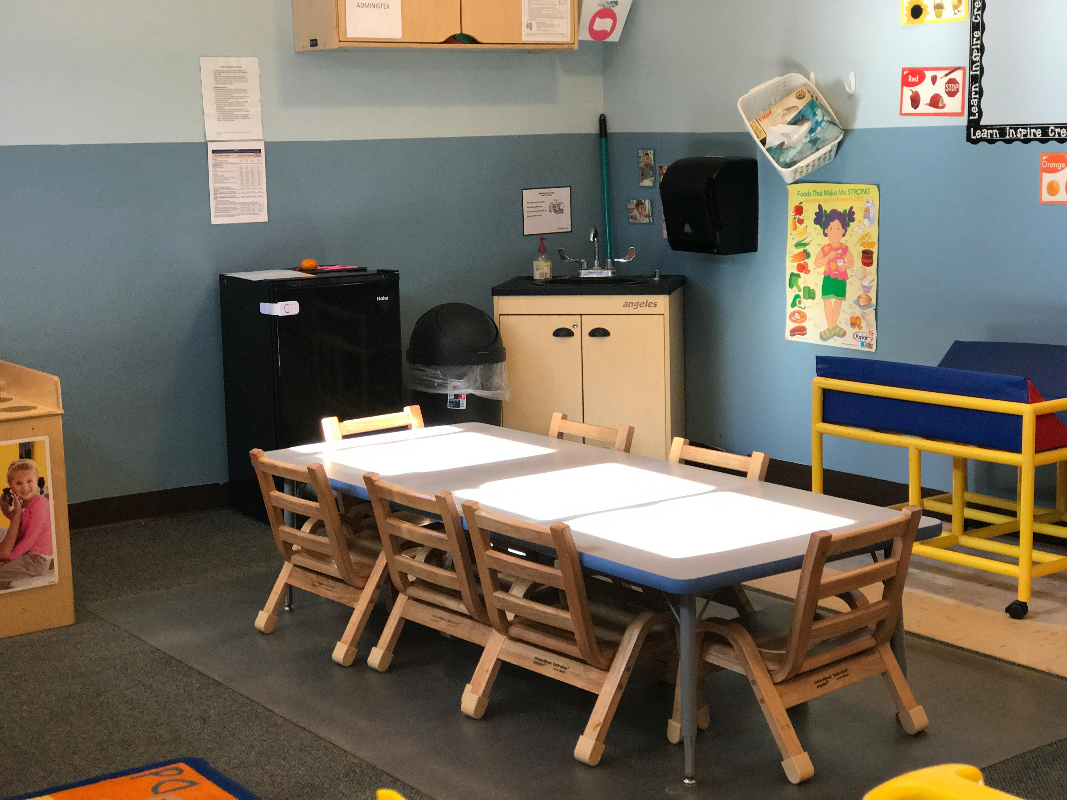 Classroom with tables and chairs, sink, and storage