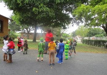 Adult and children in costumes standing outdoors