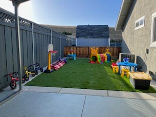 Outdoor play area with artificial turf and various toys