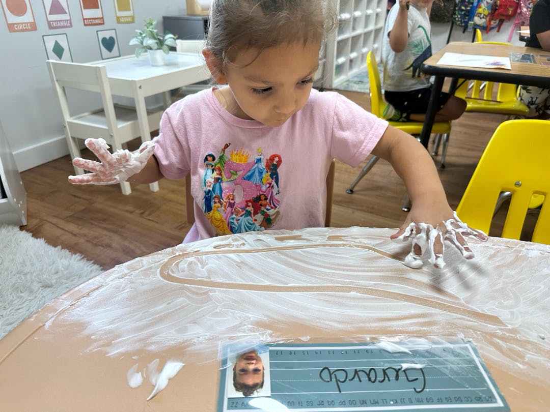 Child playing with white foam on a table
