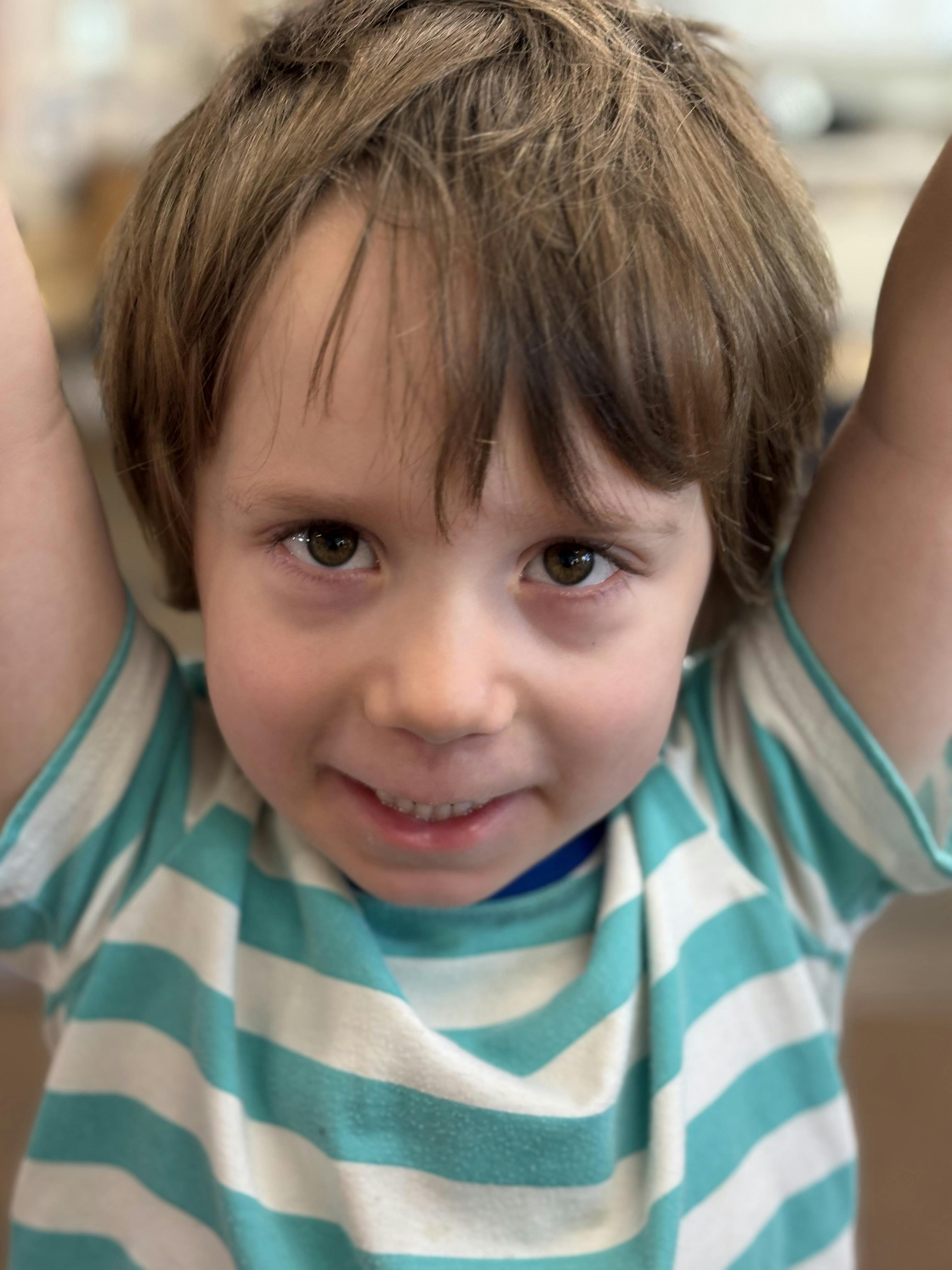 Close-up of a child with their arms raised