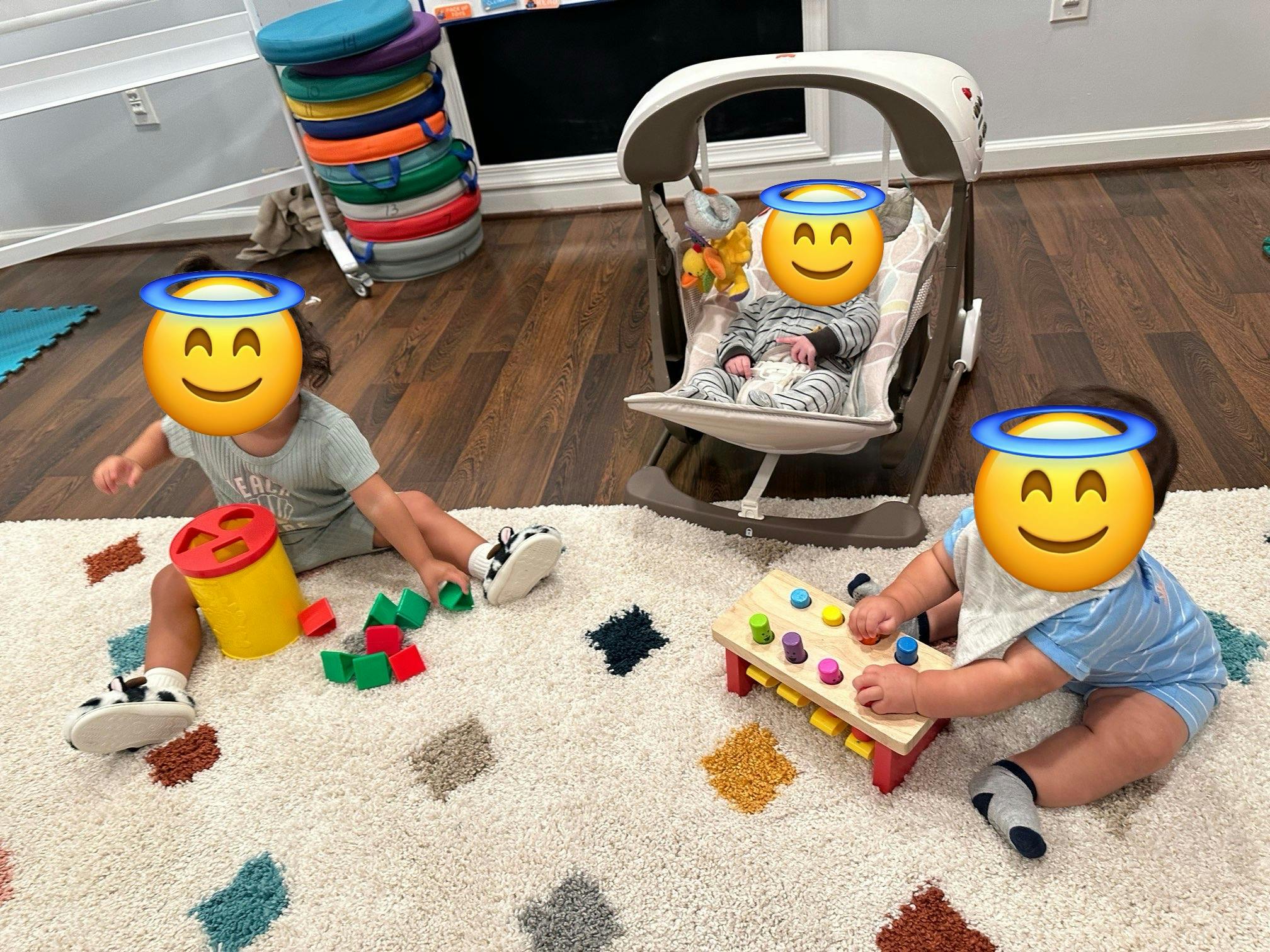 Three children playing with toys on a rug