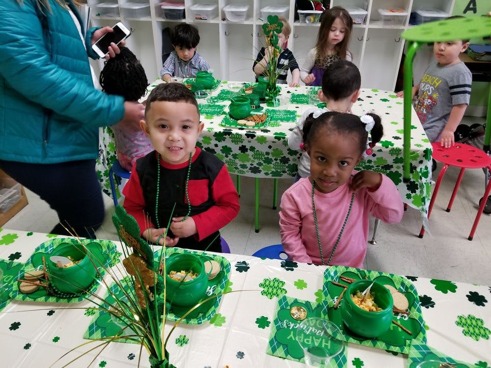 Children sitting at tables with green decorations