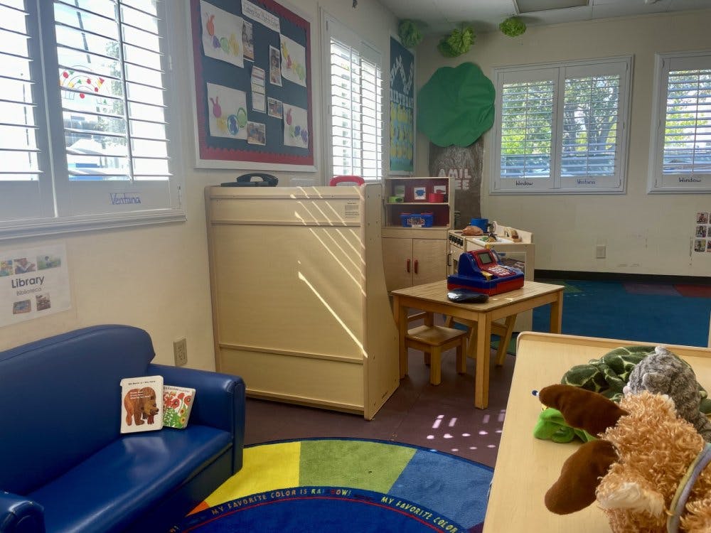 Classroom with child-sized furniture and a blue couch with colorful rug