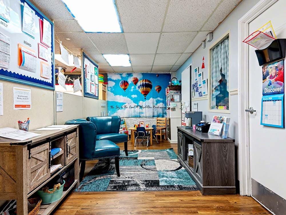 Lobby of a daycare or preschool with seating, storage, and bulletin boards