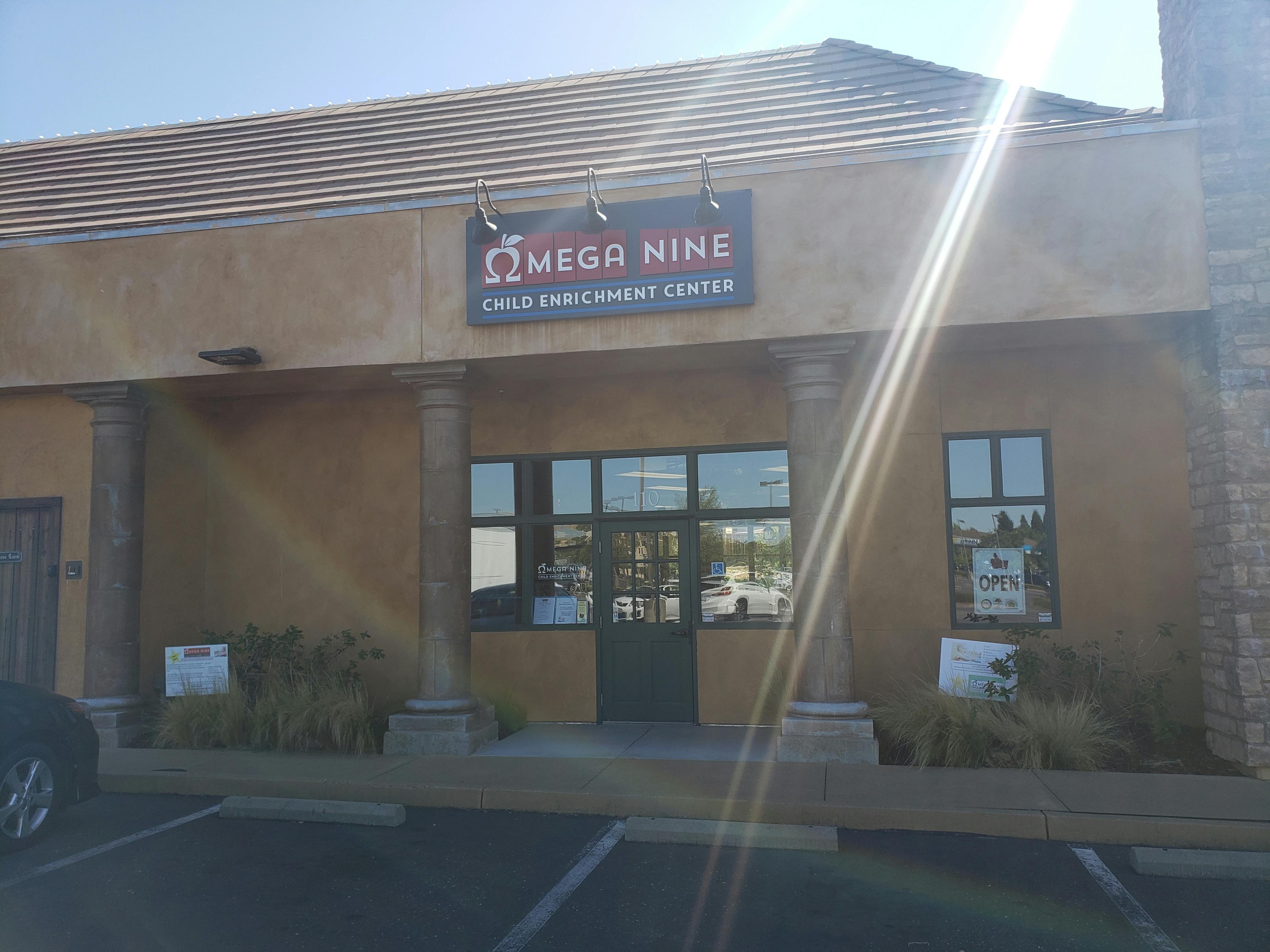 Building exterior with a sign that reads "Omega Nine Child Enrichment Center"