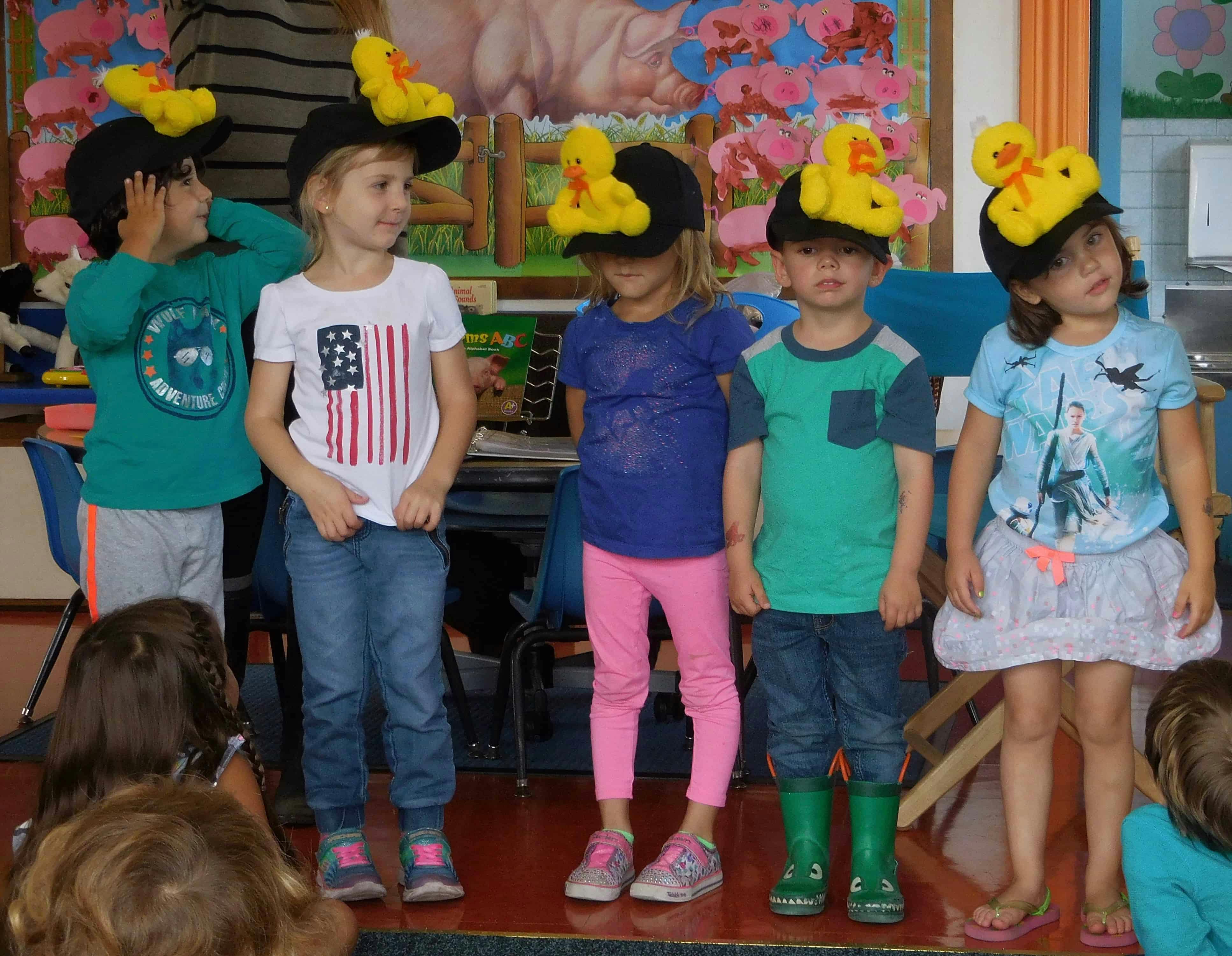 Five children wearing hats with yellow duck decorations