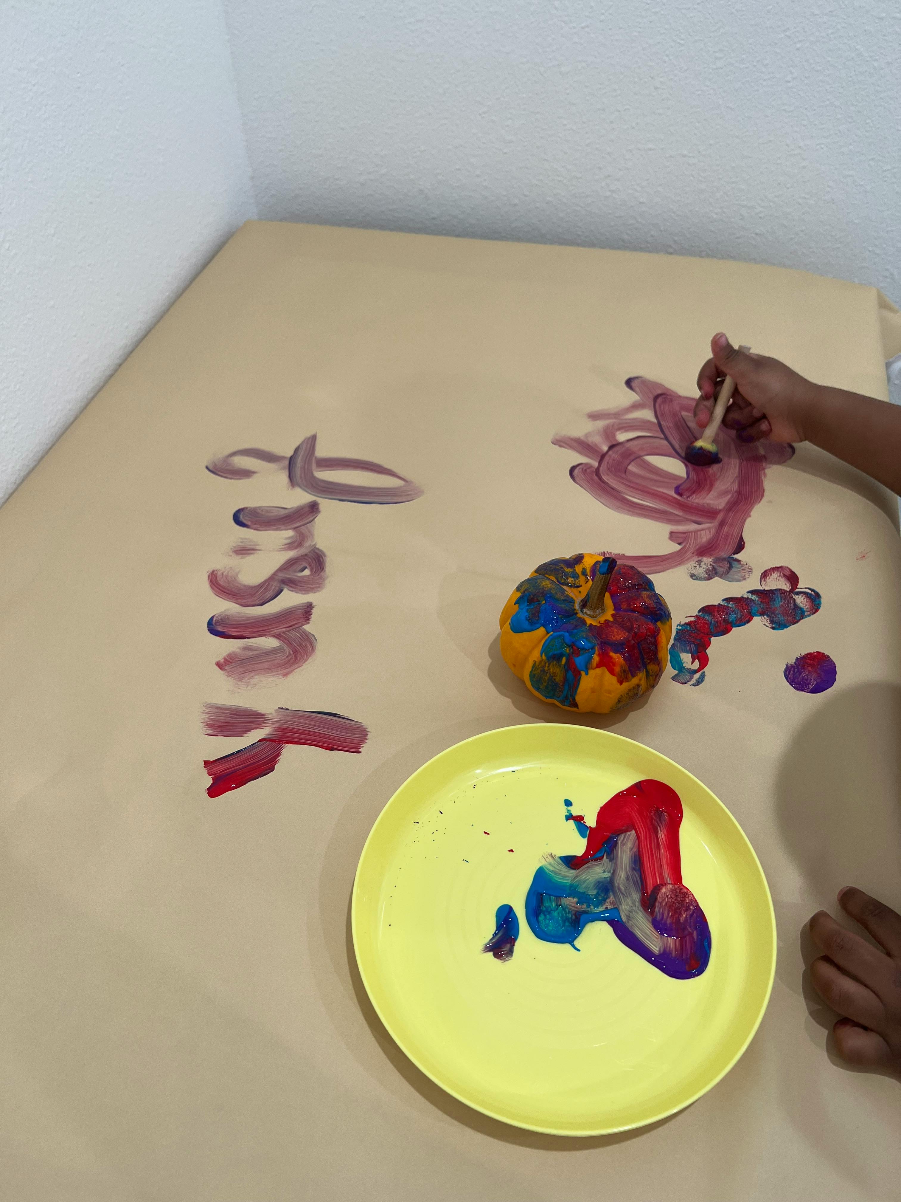 Person painting on a large sheet of paper with a brush