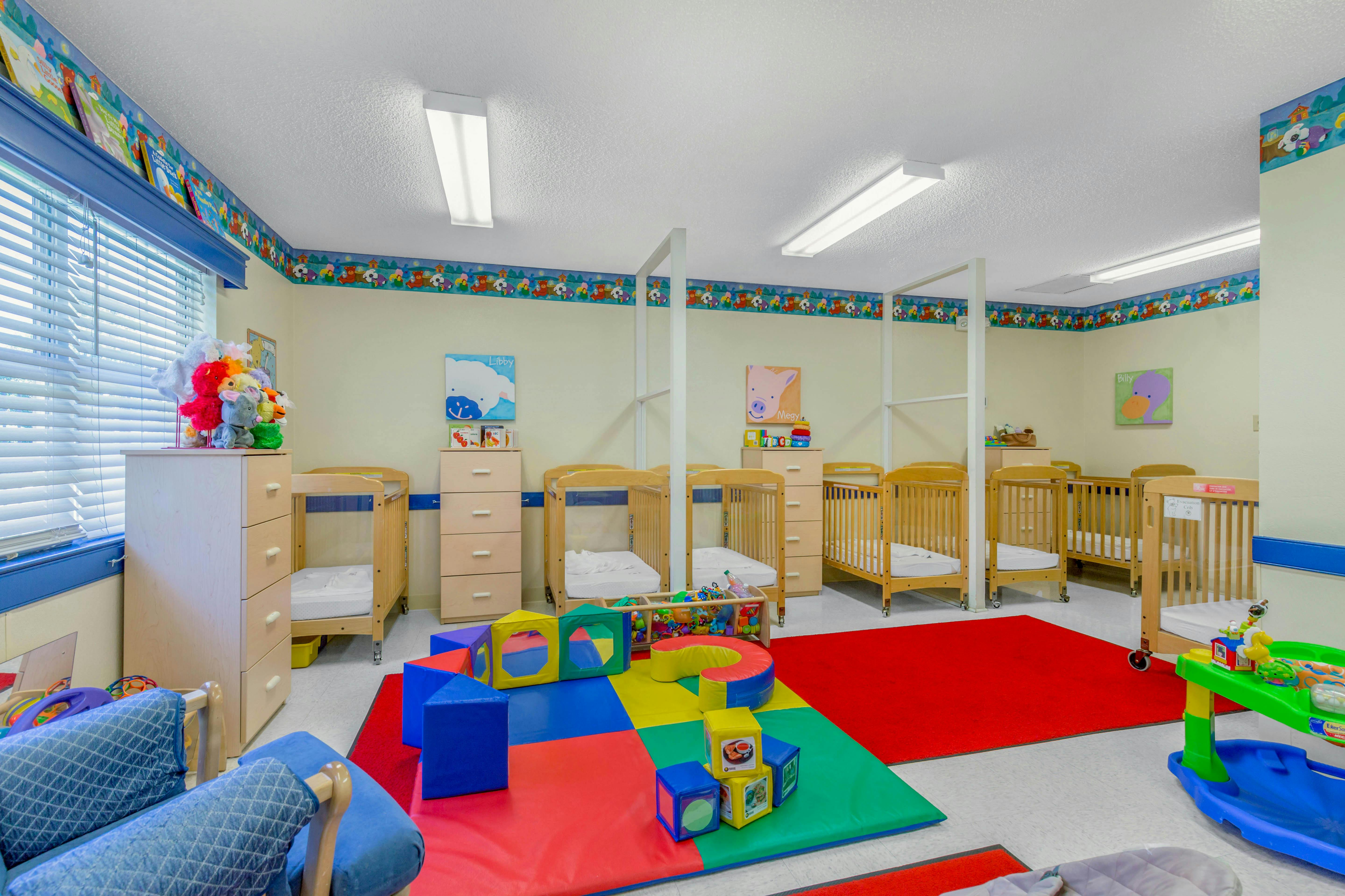 A colorful children's play area with multiple cribs