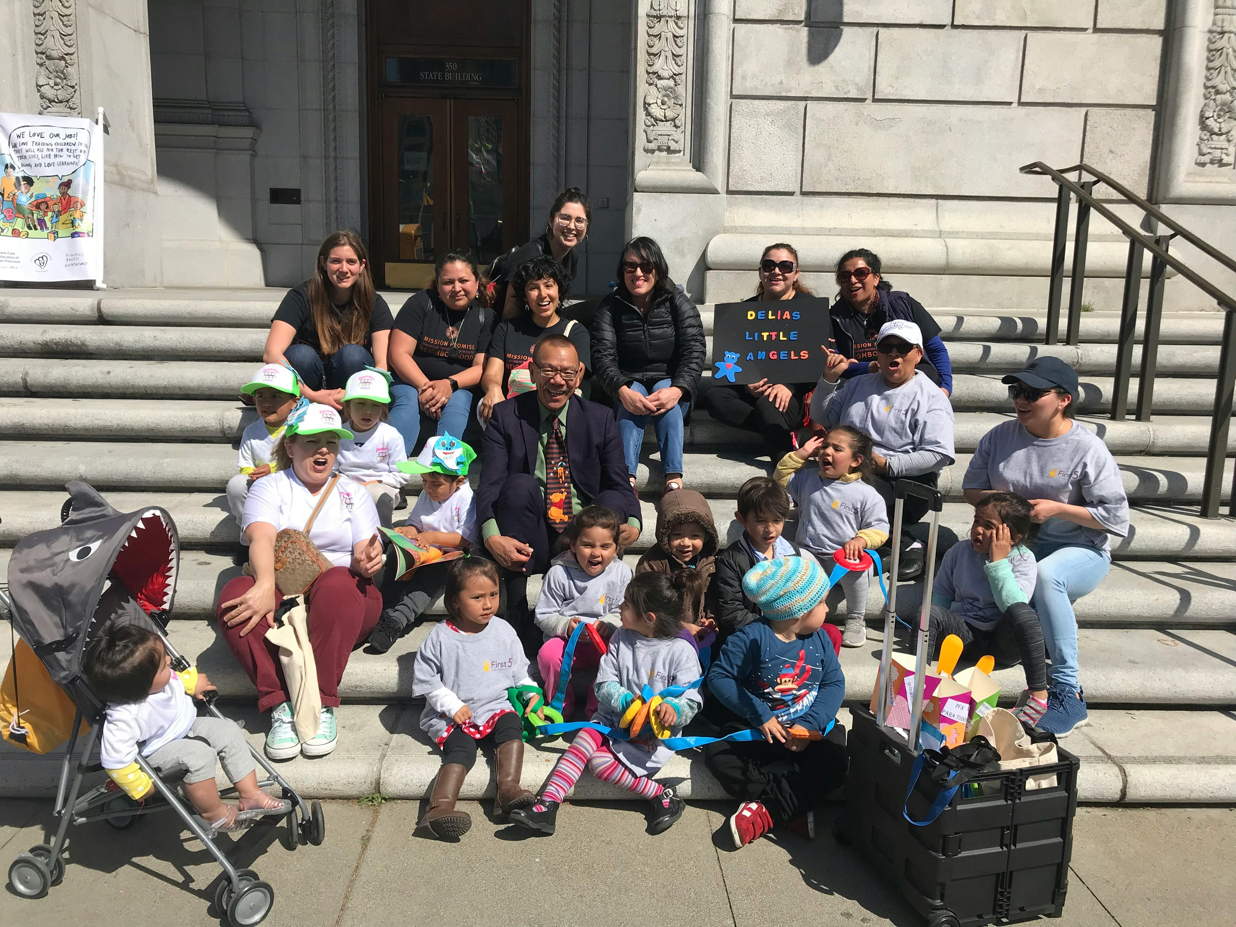 Group of people and children sitting on outdoor steps