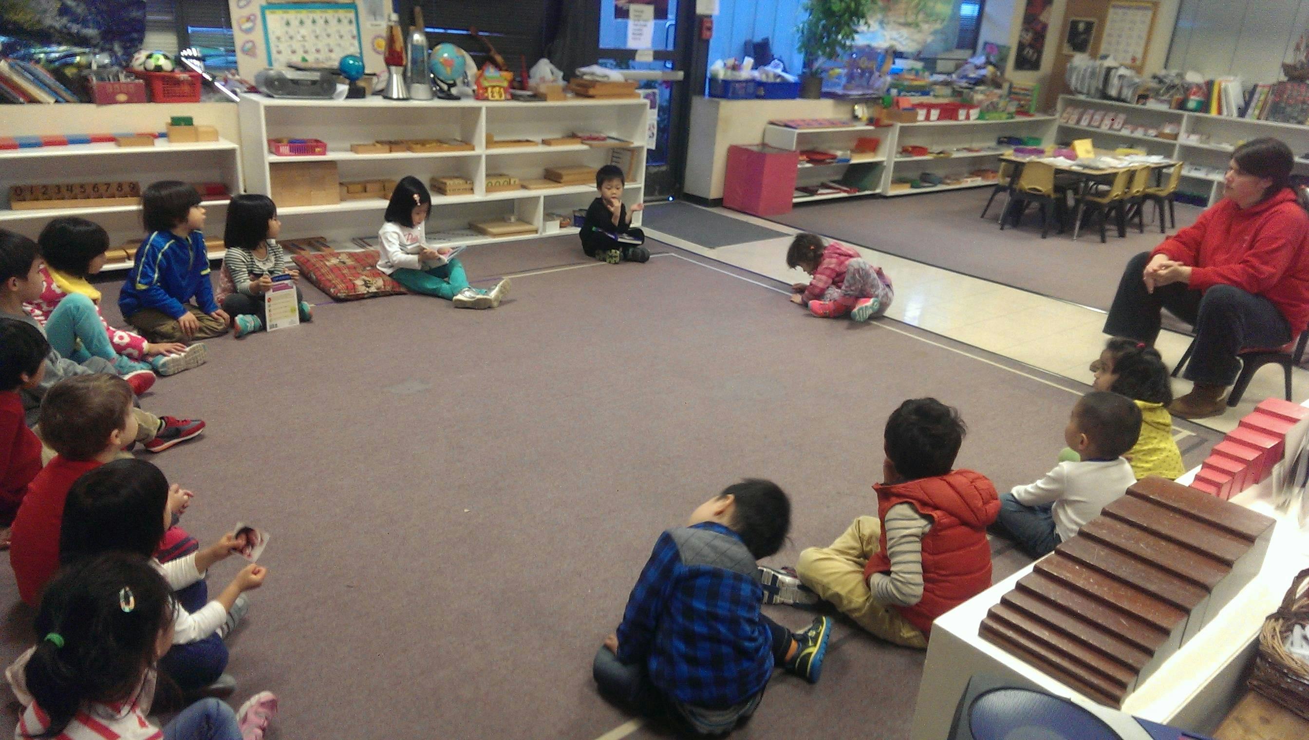 Children sitting in a circle on the floor in a classroom