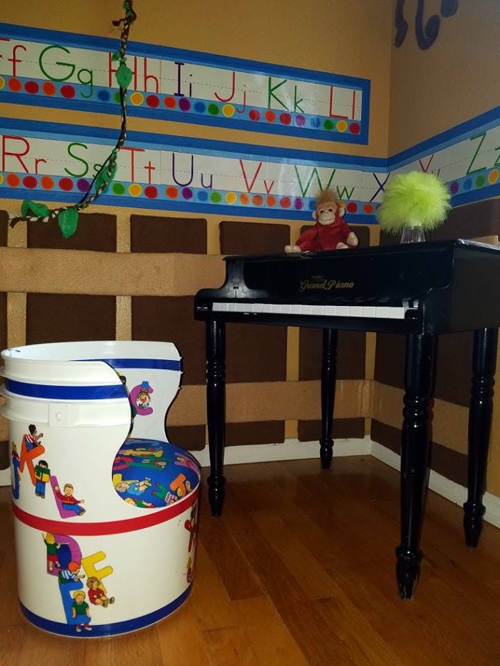 Child's chair and toy piano in a room with alphabet wall decor