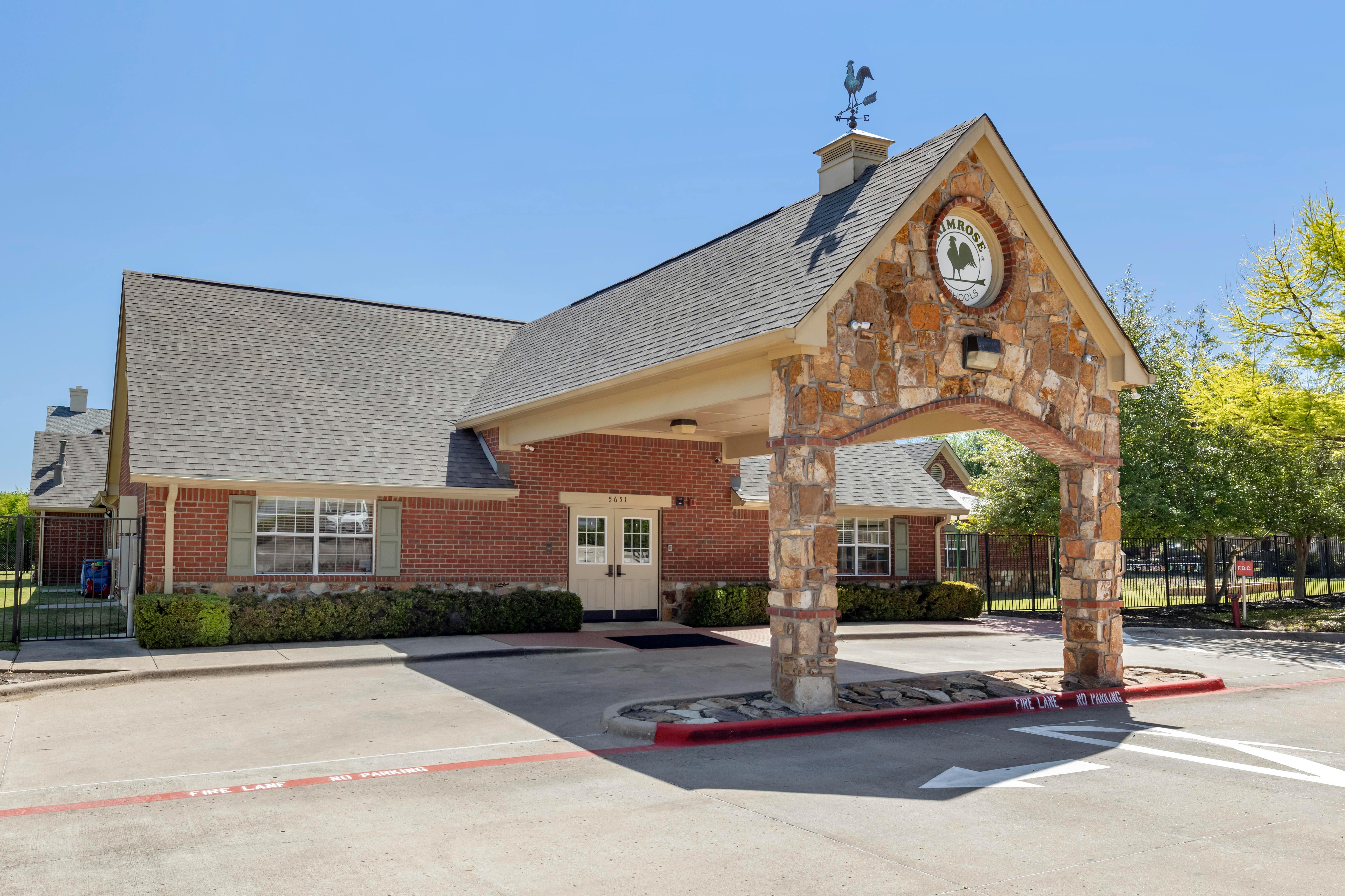 Brick building with stone archway entrance and Primrose Schools sign