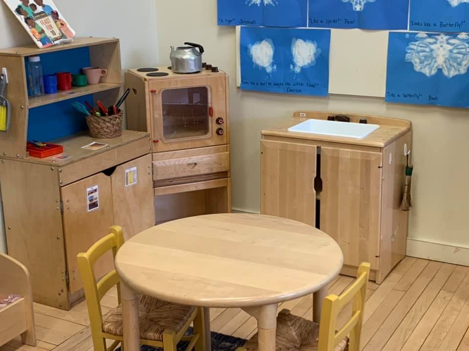 Children's play kitchen with a table and chairs