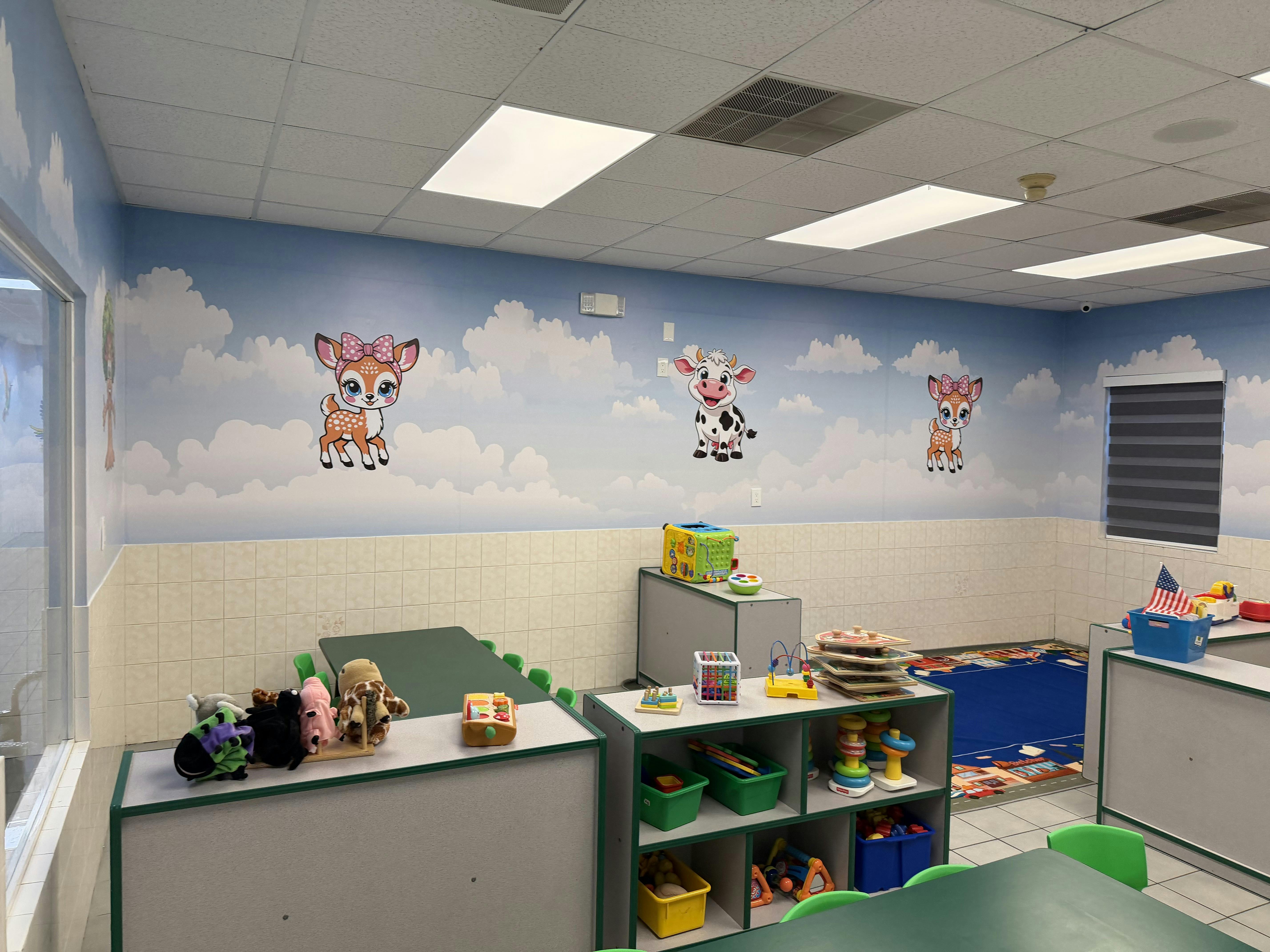 Childcare classroom with animal wall decals, tables, and toys