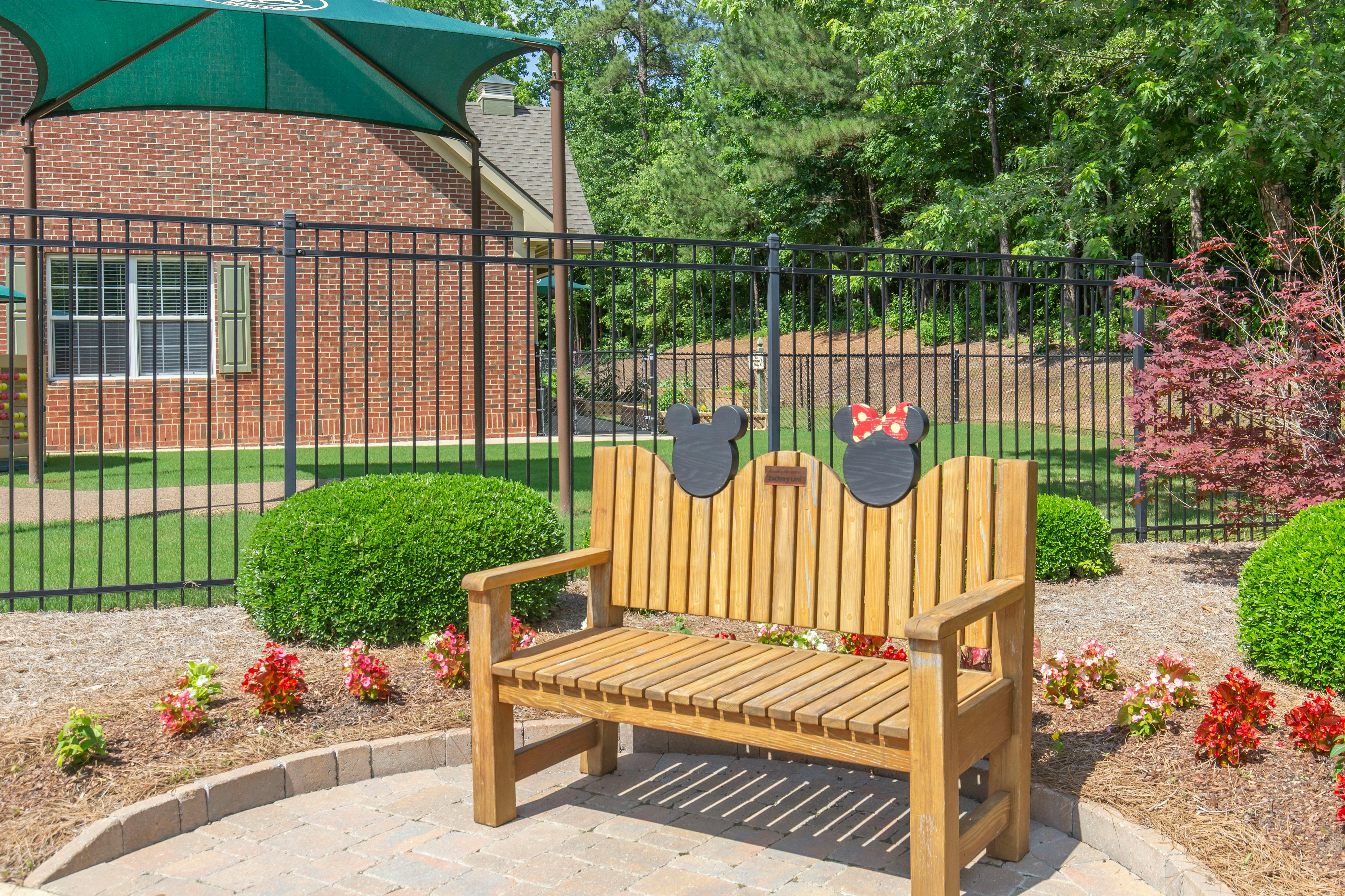 Wooden bench with Mickey and Minnie Mouse shaped cutouts