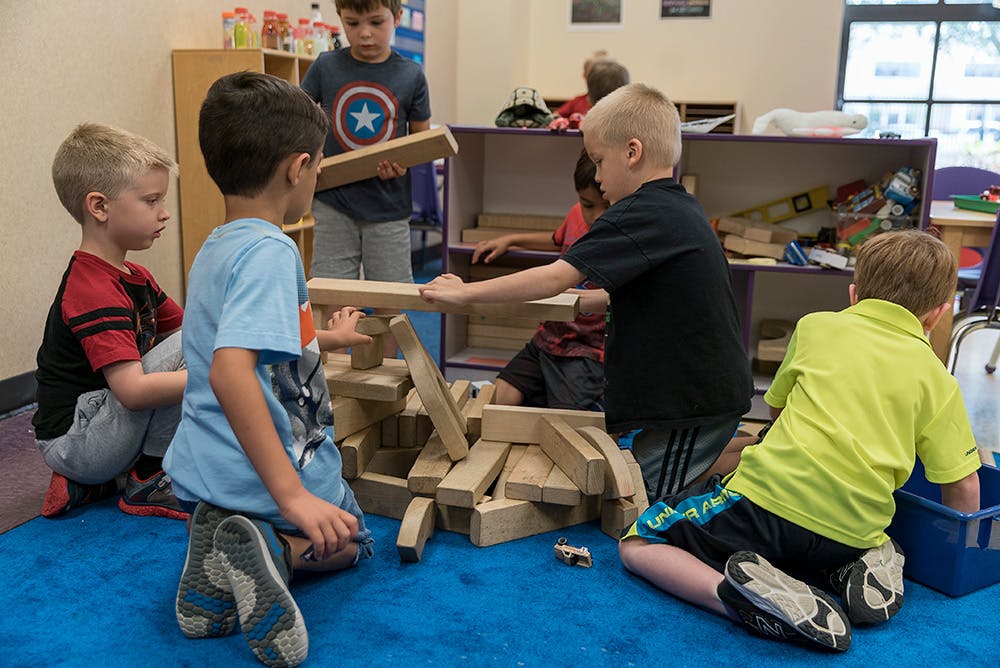 Children playing with wooden blocks in a classroom