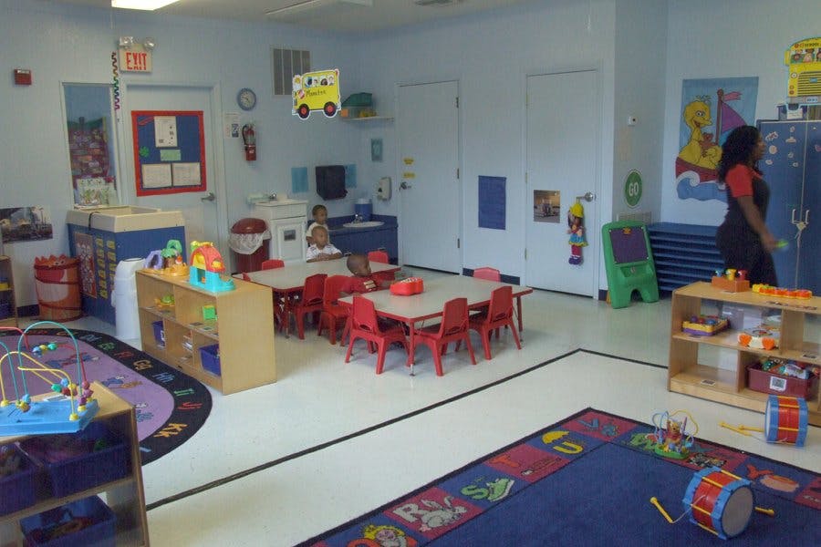 Classroom with tables, chairs, and a person standing