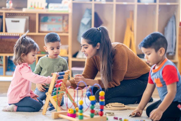 Adult and three children playing with toys on the floor