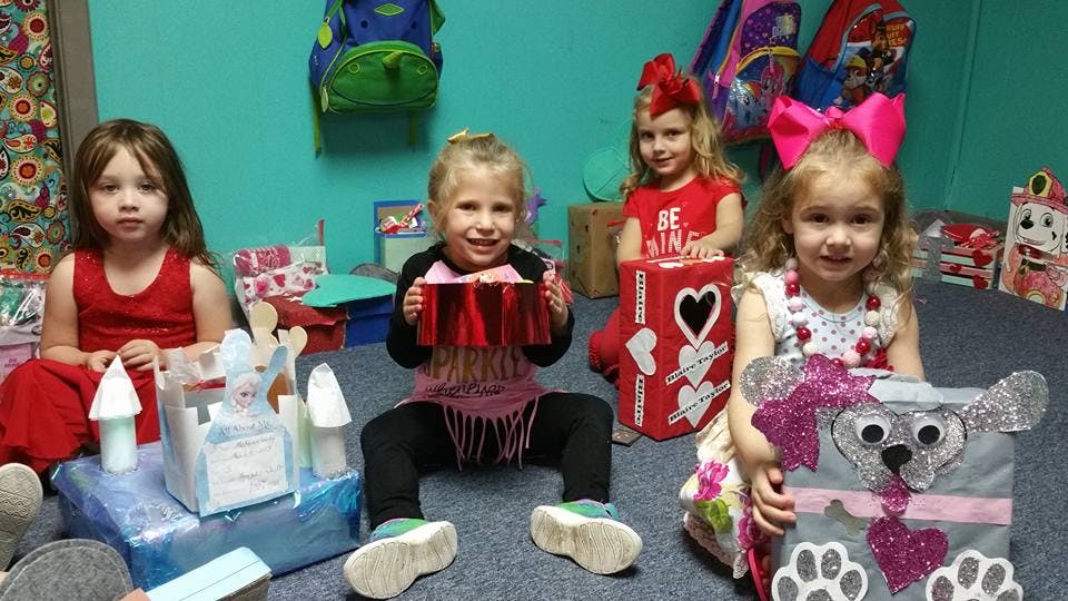 Four children sitting on the floor with crafts