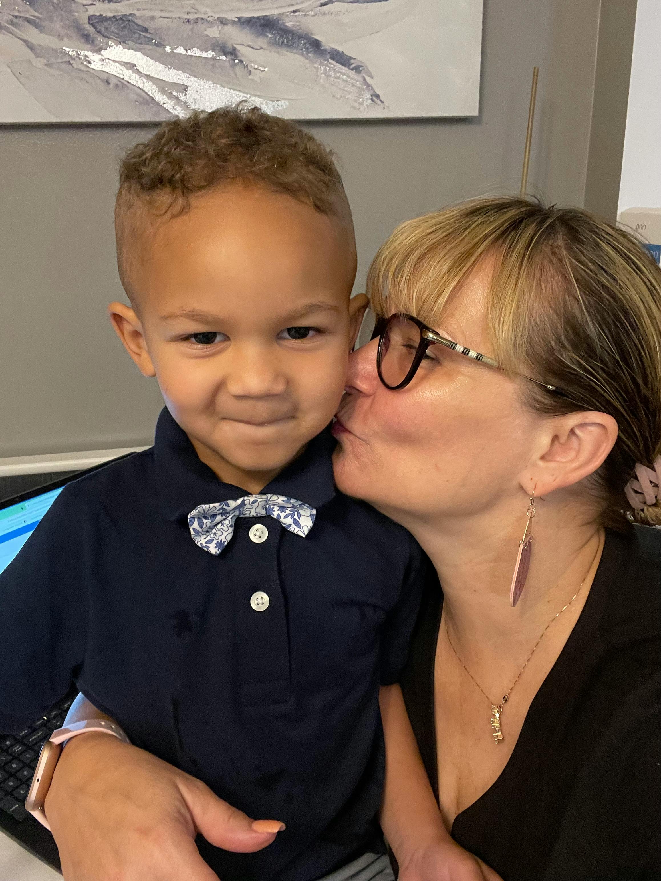 Person kissing a child on the cheek