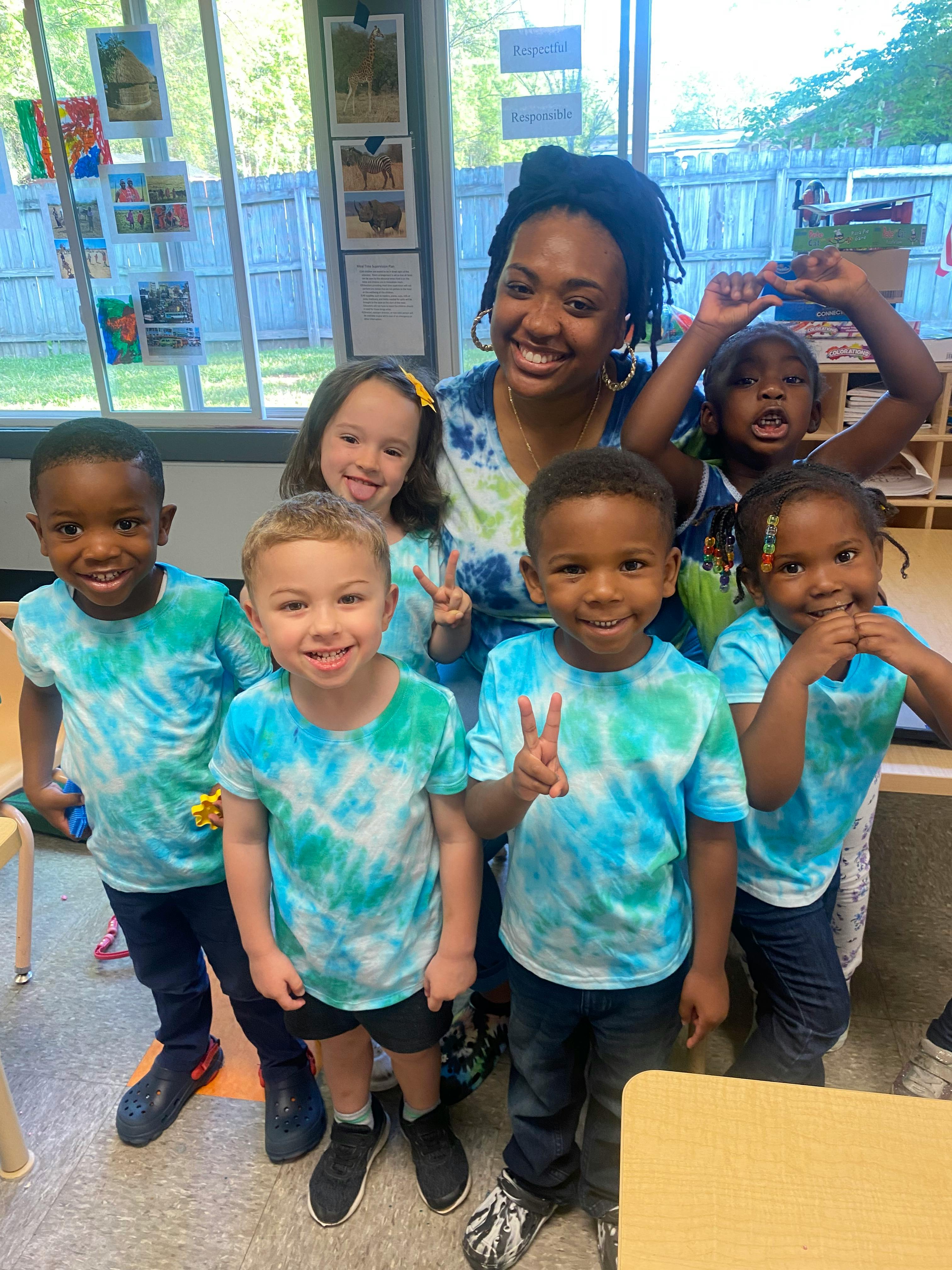 Adult and multiple children in tie-dye shirts posing