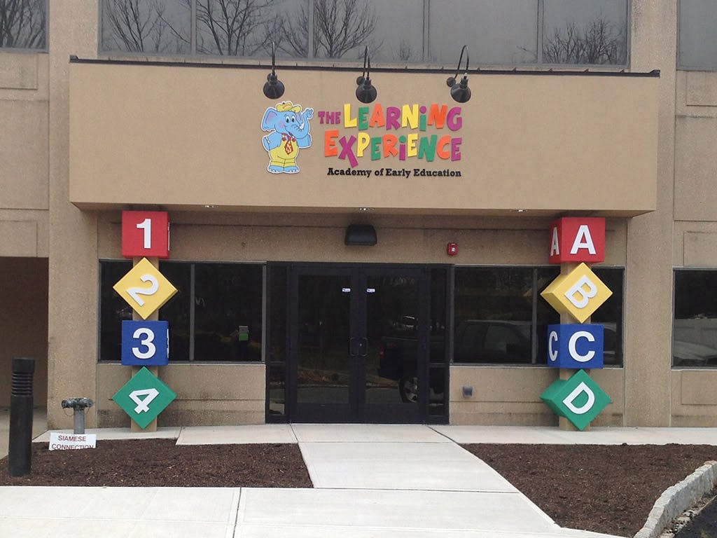 Building entrance with "The Learning Experience" sign and large letter and number blocks