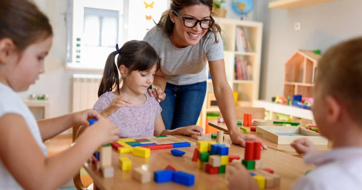 Adult and children playing with building blocks at a table