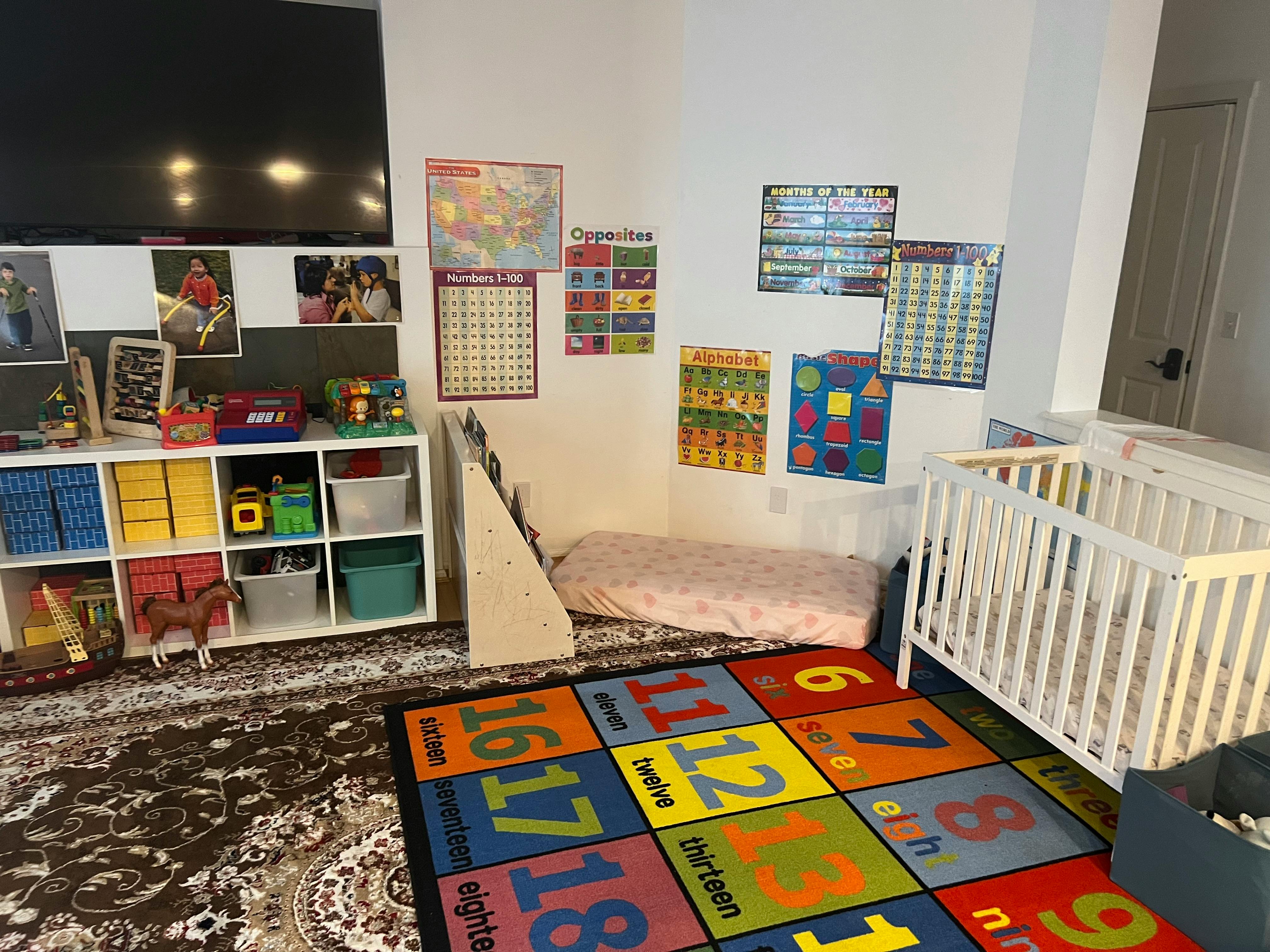 Child's room with a crib, play mat, and storage shelves