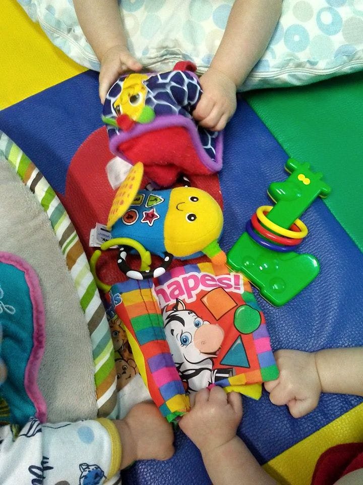 Child's hands playing with colorful baby toys