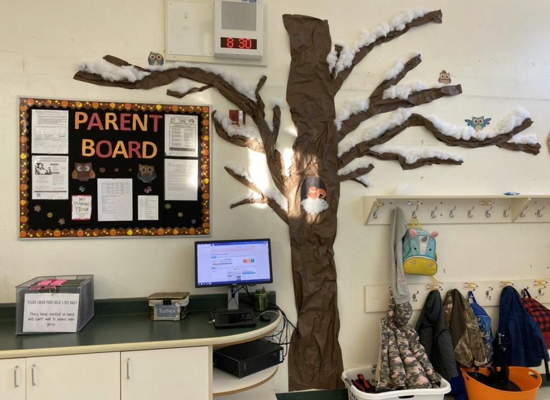 Parent board next to a tree decoration with snow on its branches