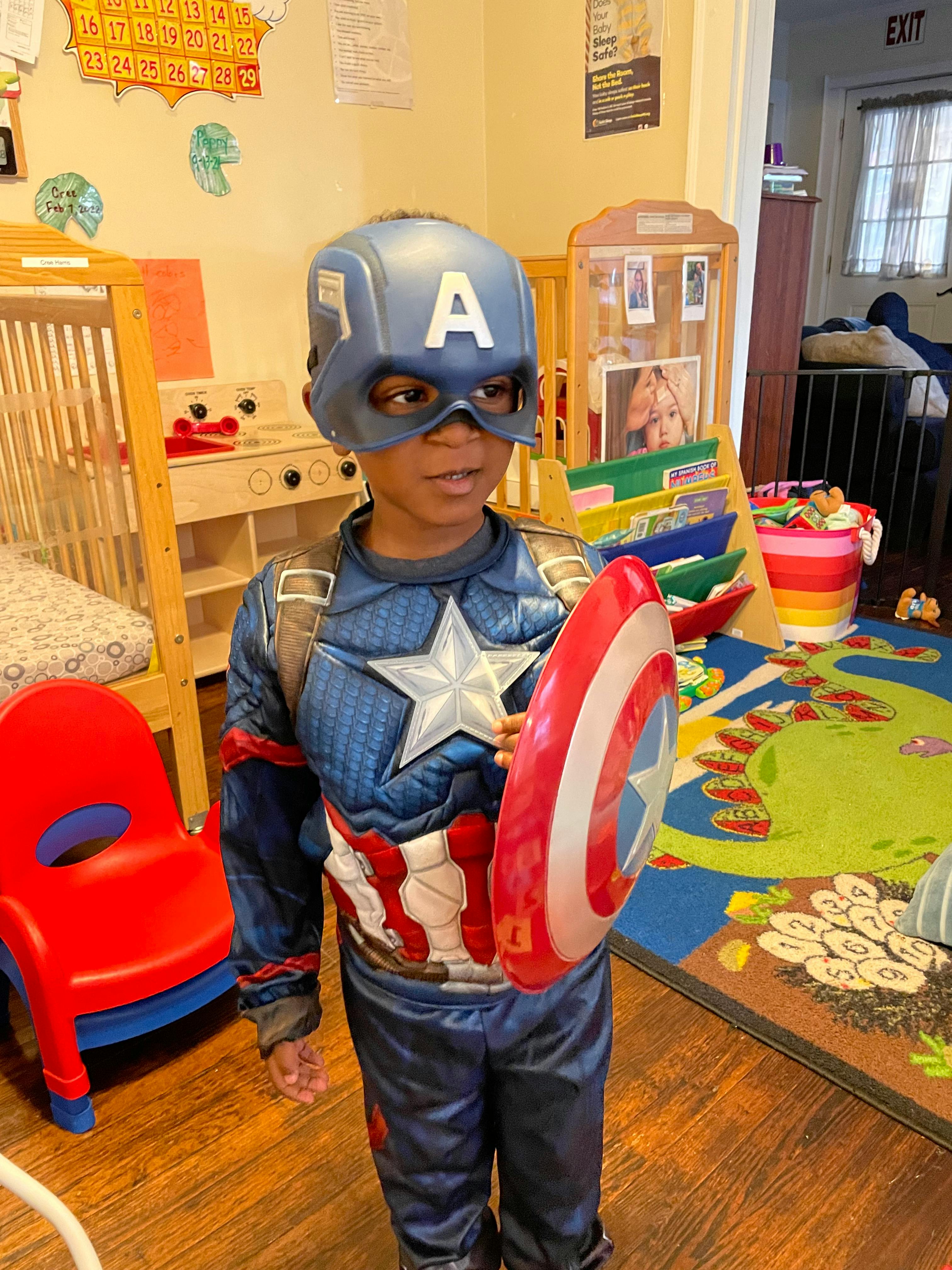 Child in Captain America costume holding a shield