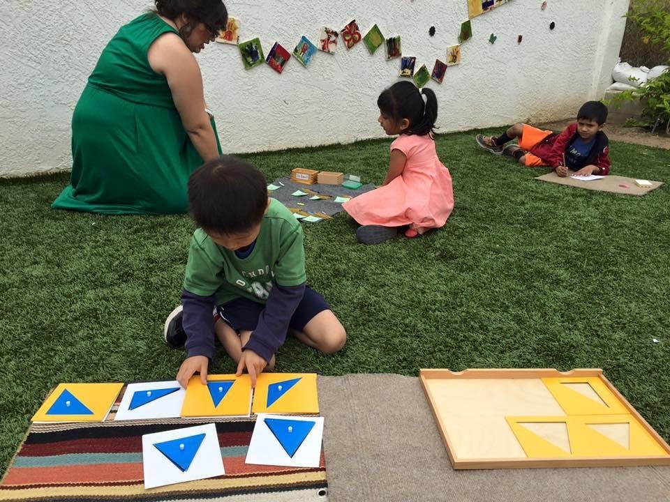 Child playing with geometric shape puzzles on grass