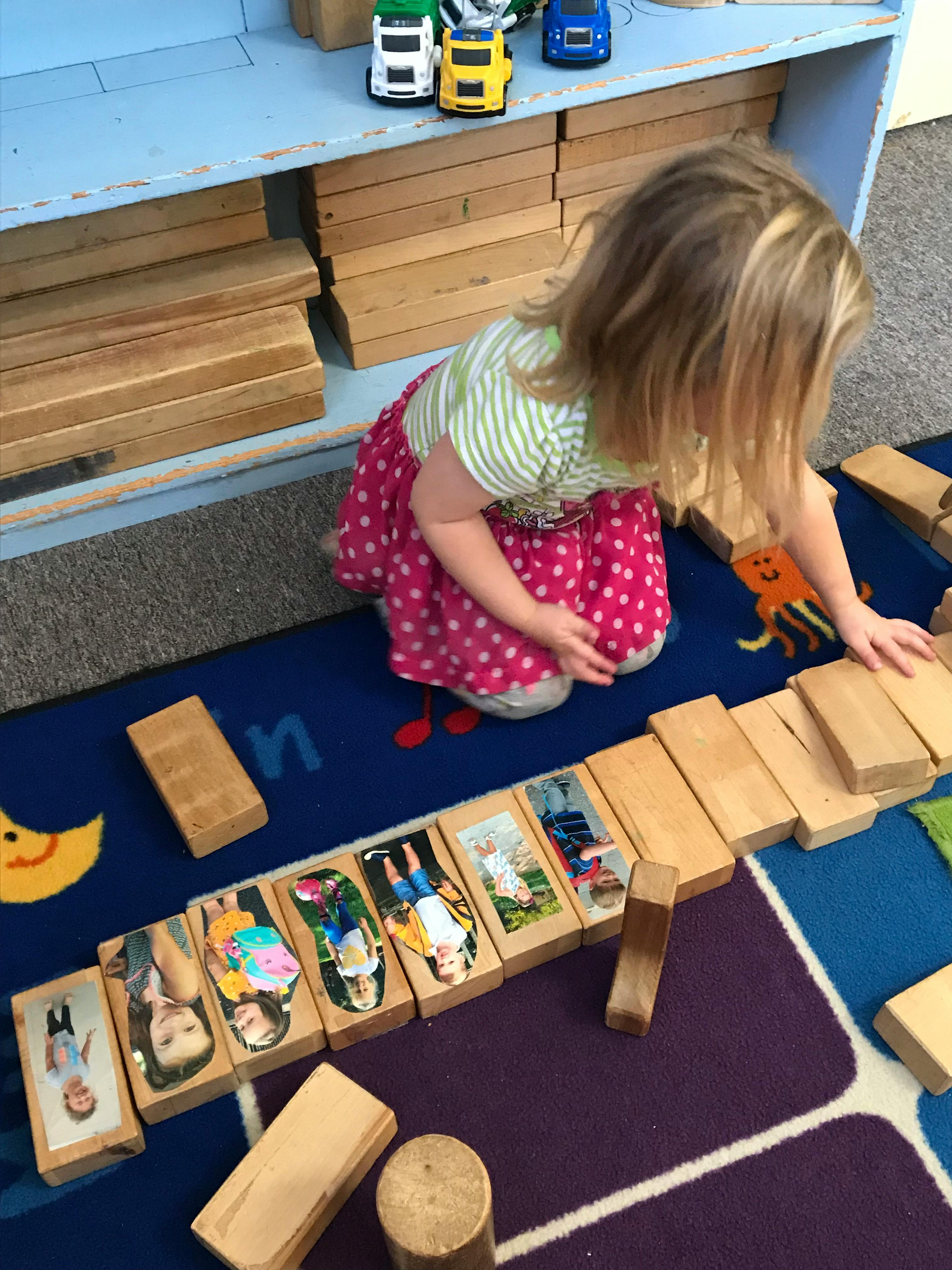 Child playing with wooden blocks on a rug