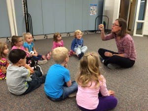 Adult and children sitting on floor in a circle
