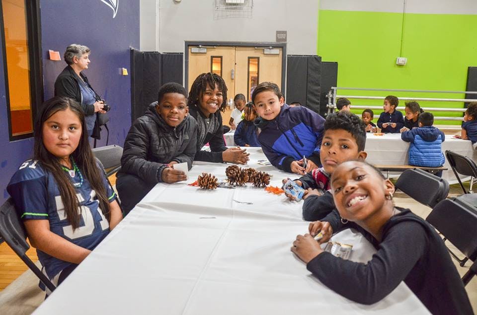 Children sitting at a table with pinecones