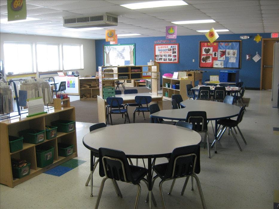 An empty classroom with various tables and chairs set up