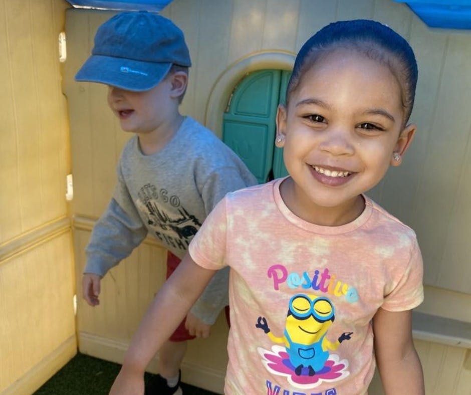 Two children playing, one in a hat and one in a t-shirt with a cartoon character